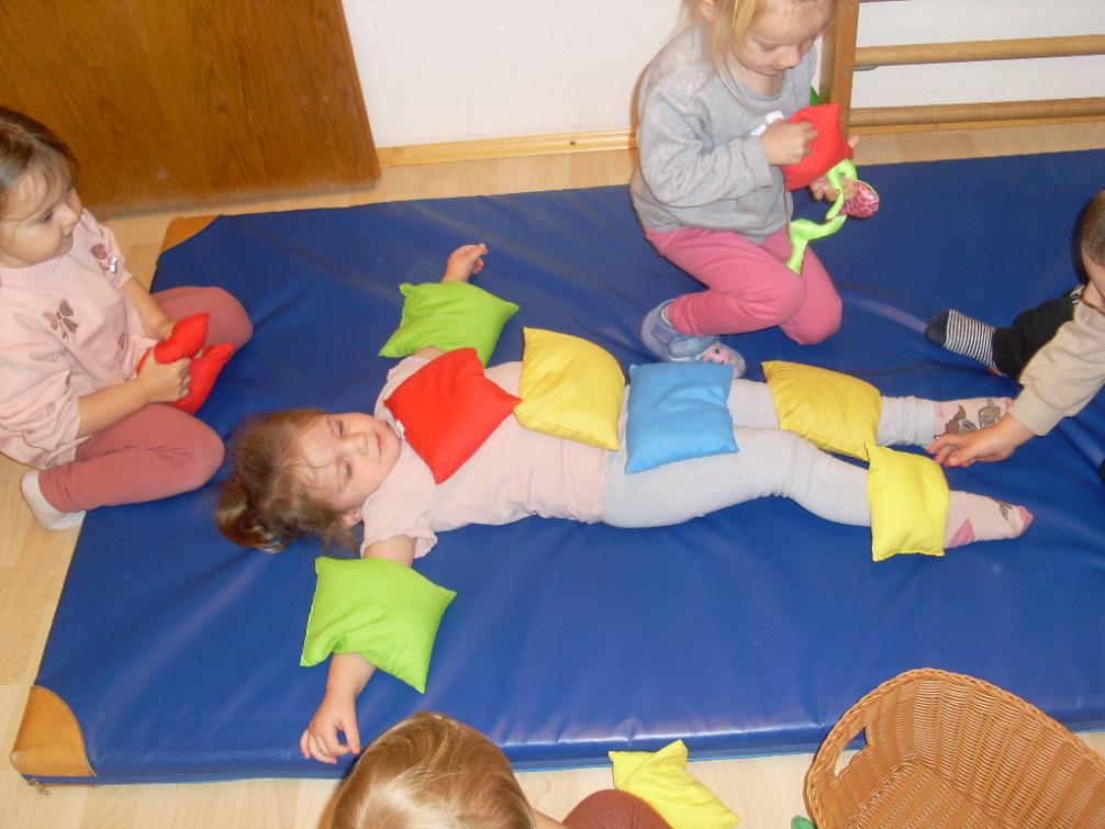 Sandsäckchen werden auf ein Kind gelegt